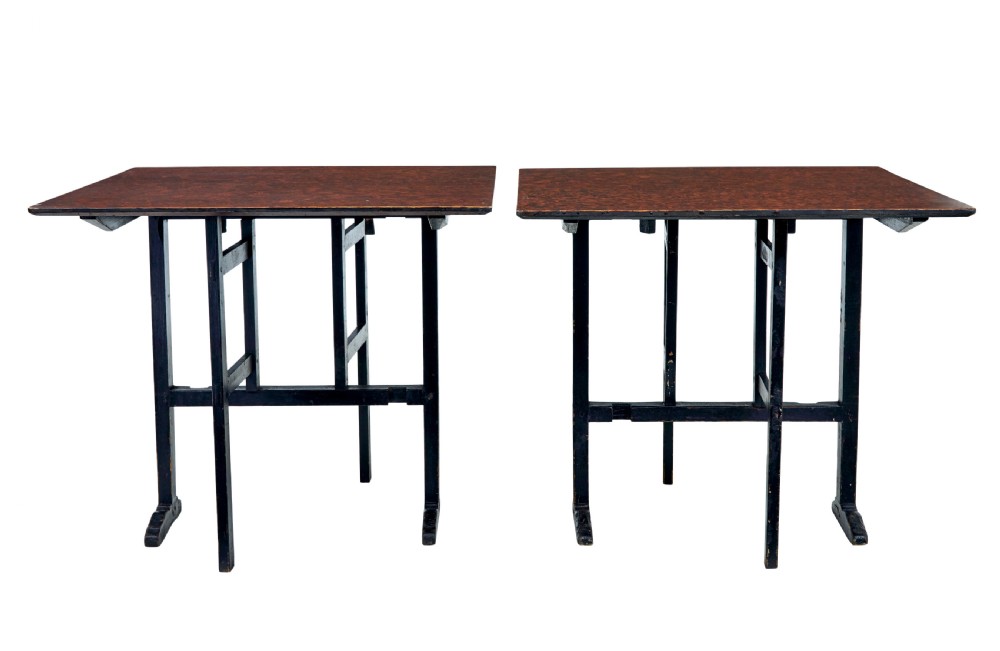 A pair of 19th-century Swedish folding tables featuring square tops with mottled brown ragwork painted surfaces supported on dark painted trestle bases. View VII