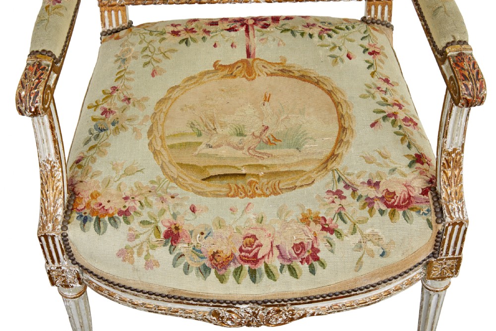 A five-piece French giltwood salon suite comprising four carved armchairs and a matching sofa, all upholstered in cream woven tapestry with floral and figurative medallions. View XI