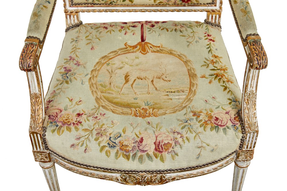 A five-piece French giltwood salon suite comprising four carved armchairs and a matching sofa, all upholstered in cream woven tapestry with floral and figurative medallions. View XIII