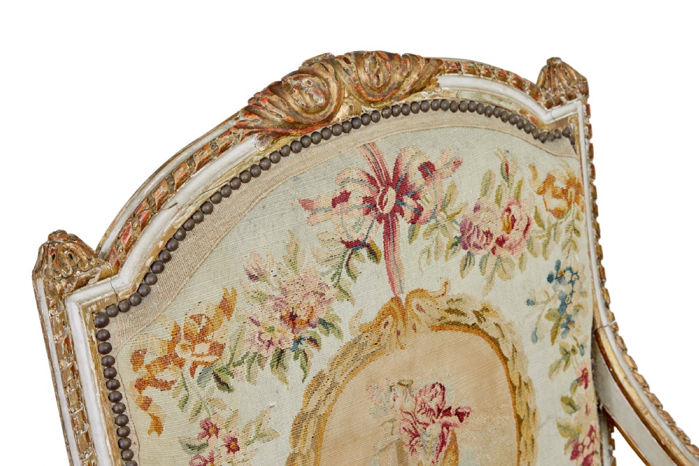 A five-piece French giltwood salon suite comprising four carved armchairs and a matching sofa, all upholstered in cream woven tapestry with floral and figurative medallions. View XIV