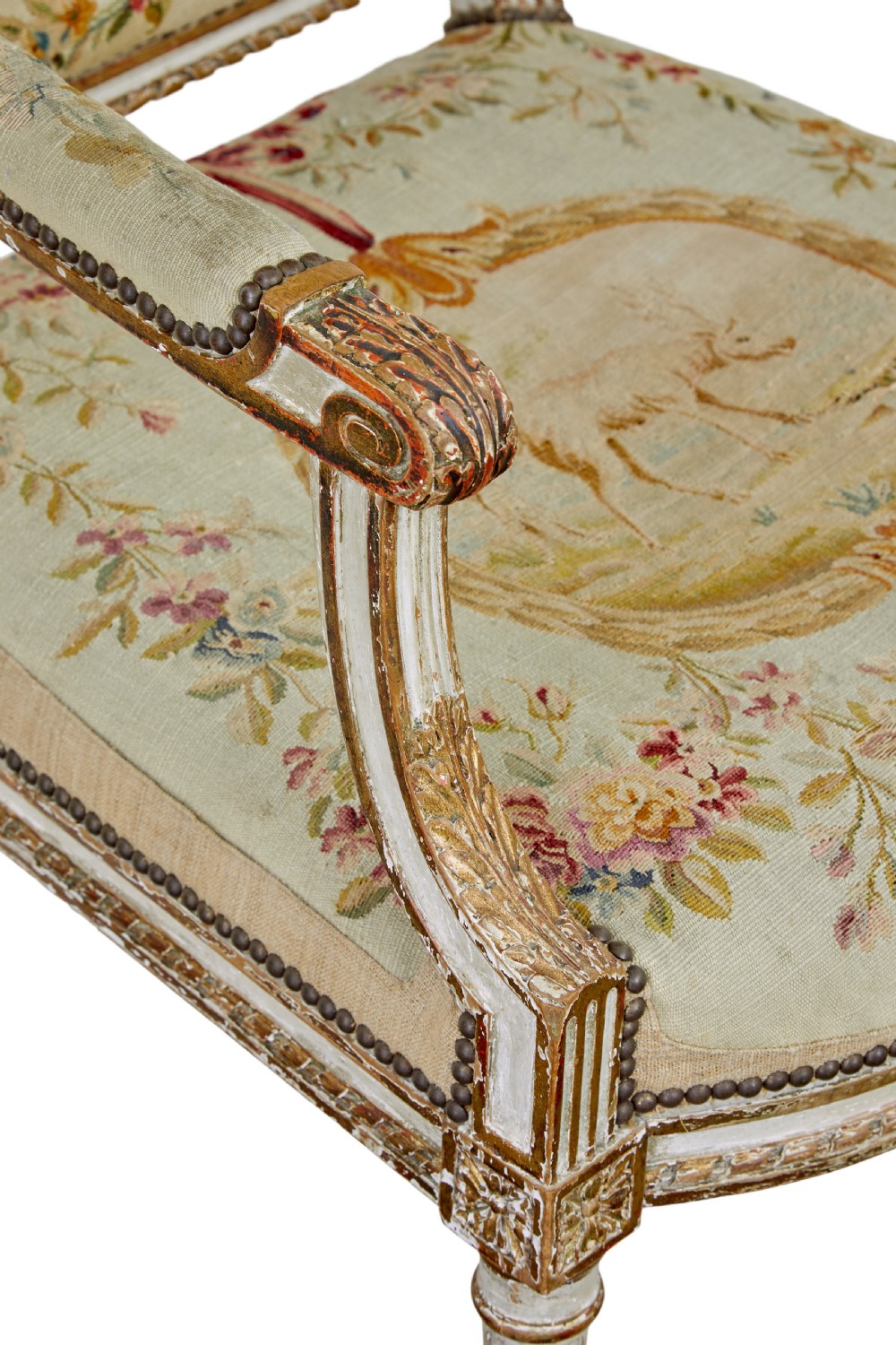 A five-piece French giltwood salon suite comprising four carved armchairs and a matching sofa, all upholstered in cream woven tapestry with floral and figurative medallions. View XV