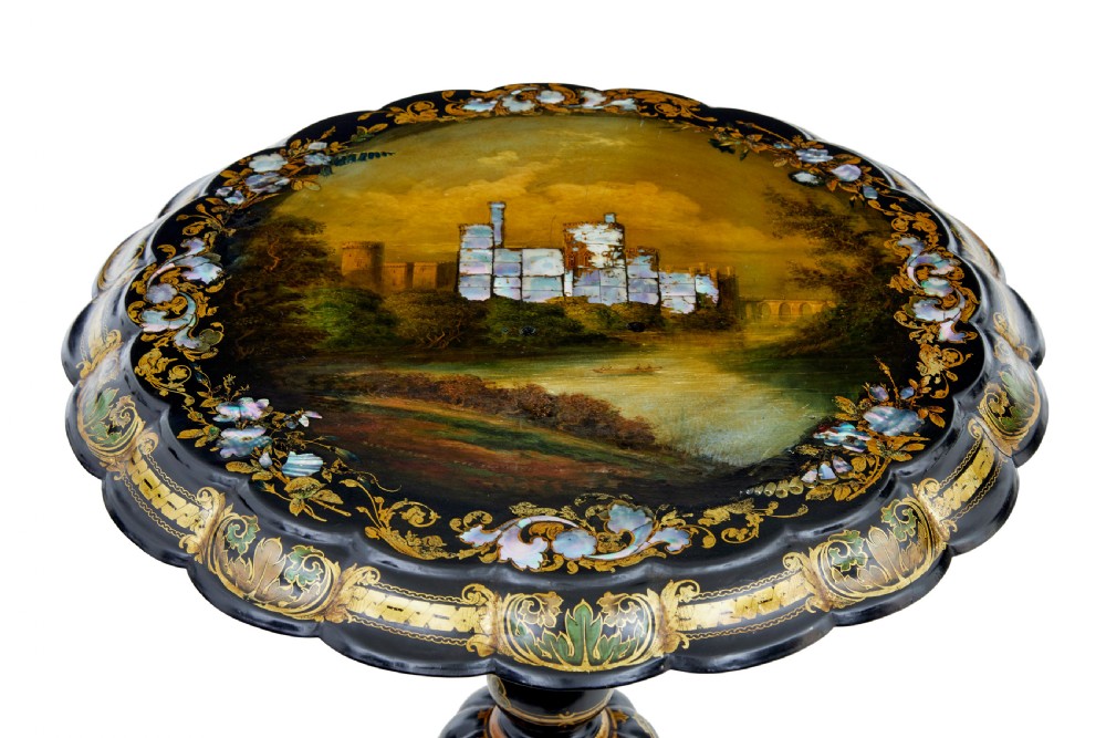 A 19th-century black lacquered papier-mache tilt-top table with a scalloped edge, hand-painted landscape, mother-of-pearl inlay, and gilded floral scrollwork on a turned pedestal. View II