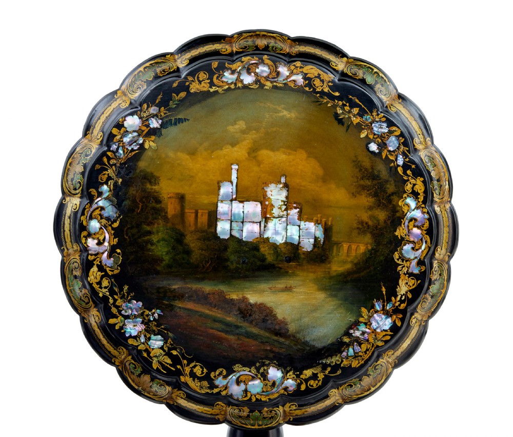 A 19th-century black lacquered papier-mache tilt-top table with a scalloped edge, hand-painted landscape, mother-of-pearl inlay, and gilded floral scrollwork on a turned pedestal. View V