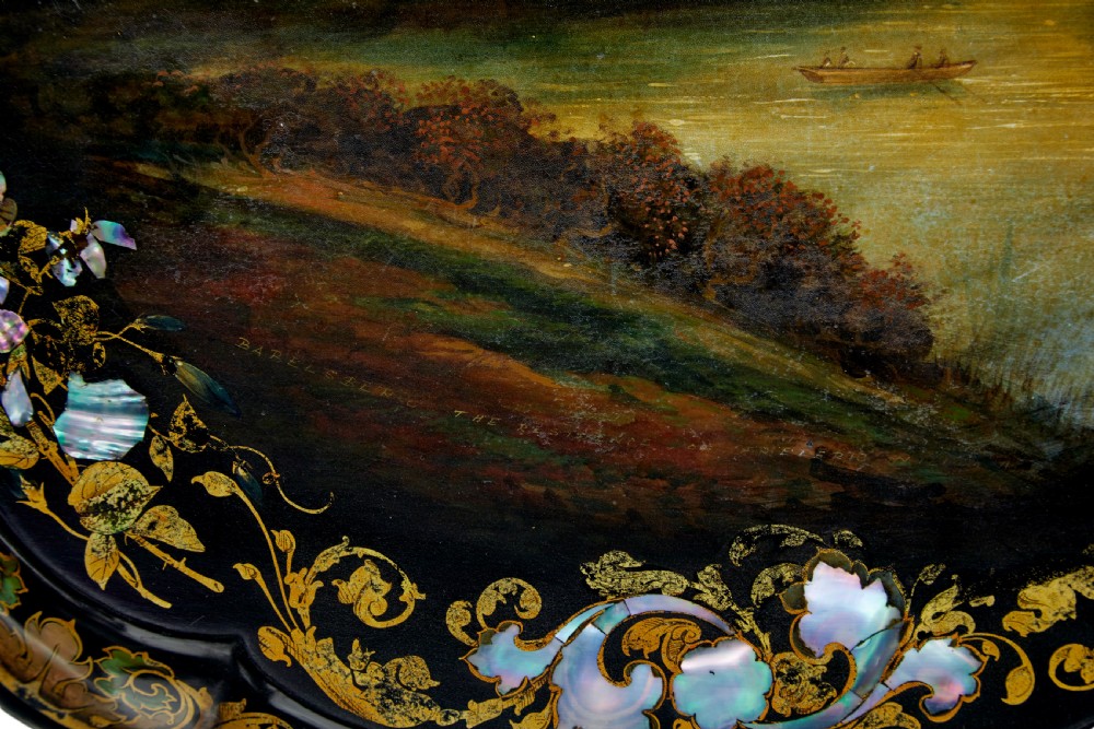 A 19th-century black lacquered papier-mache tilt-top table with a scalloped edge, hand-painted landscape, mother-of-pearl inlay, and gilded floral scrollwork on a turned pedestal. View VIII