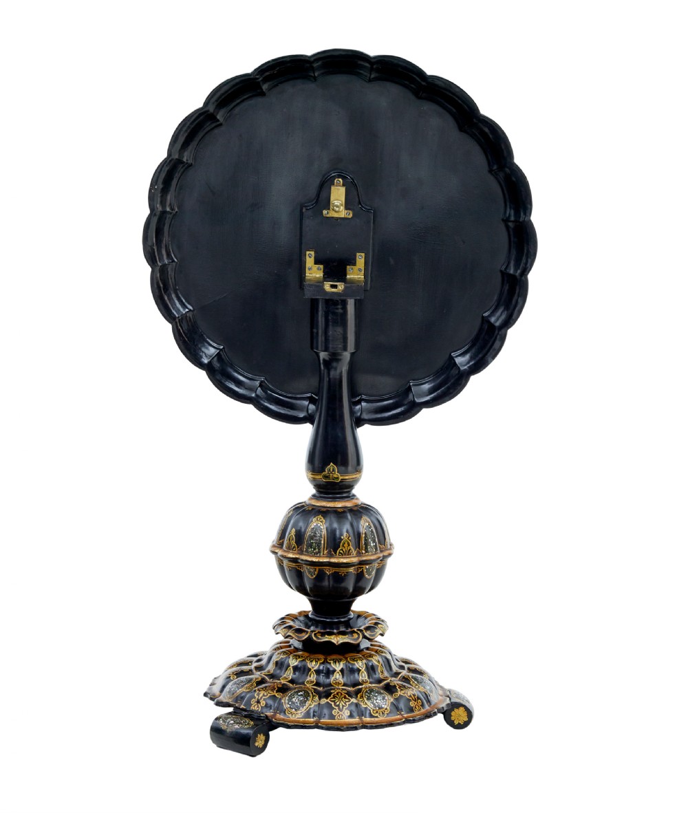 A 19th-century black lacquered papier-mache tilt-top table with a scalloped edge, hand-painted landscape, mother-of-pearl inlay, and gilded floral scrollwork on a turned pedestal. View IX