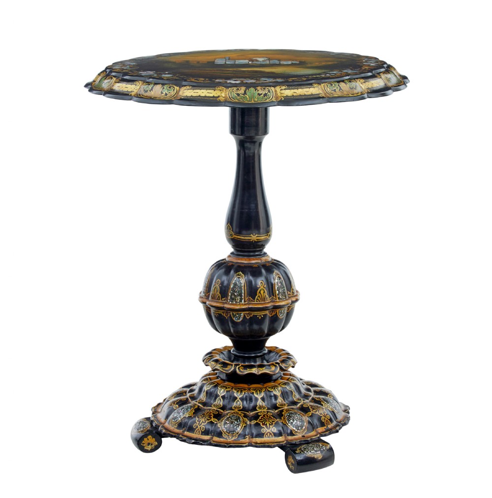 A 19th-century black lacquered papier-mache tilt-top table with a scalloped edge, hand-painted landscape, mother-of-pearl inlay, and gilded floral scrollwork on a turned pedestal. View X