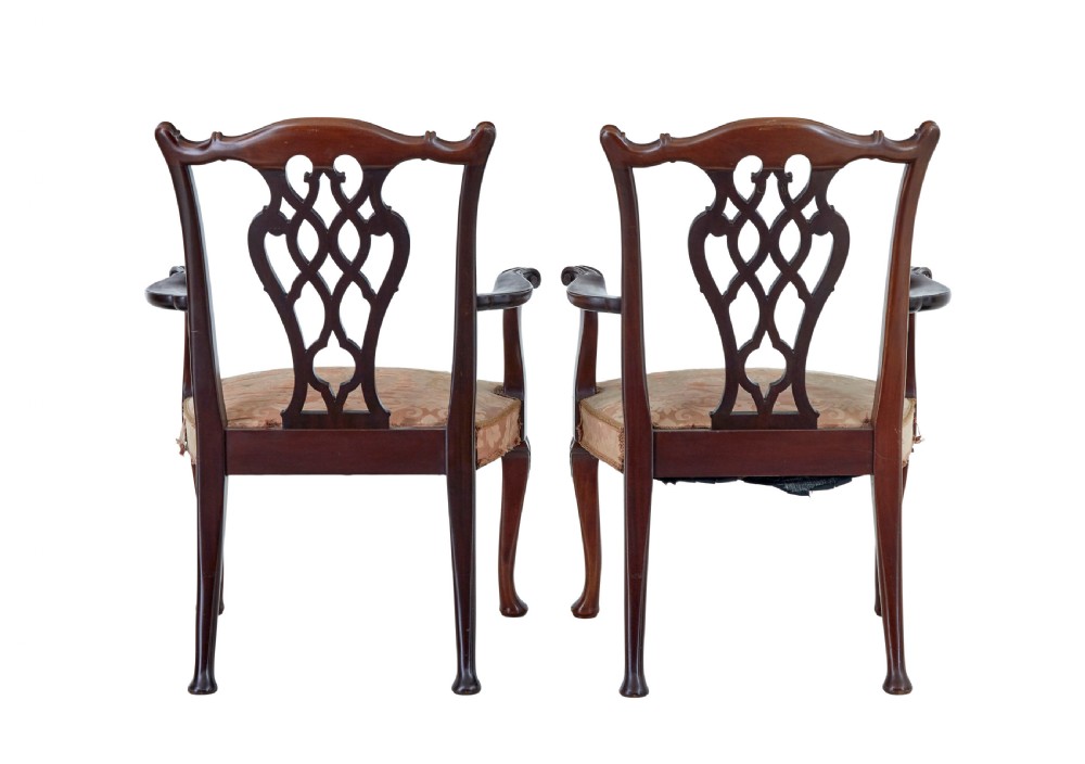 A pair of early 20th-century Chippendale Revival mahogany armchairs featuring carved pierced splat backs, serpentine top rails, curved arms, and cabriole legs. View VIII