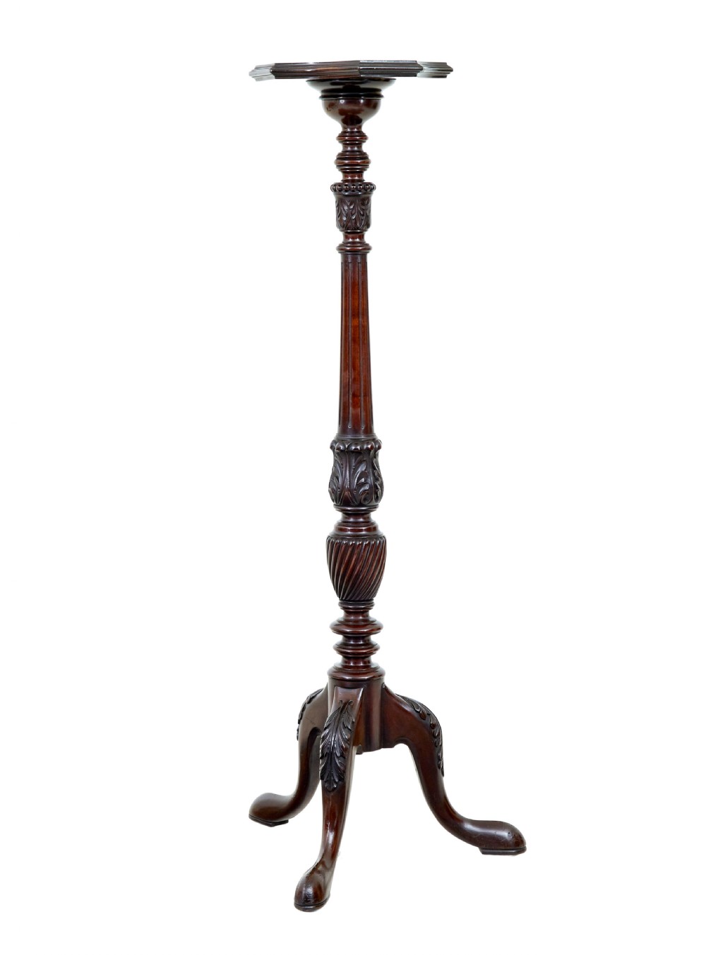 An early 20th-century carved mahogany torchere stand featuring a shaped top, a fluted column with acanthus leaf details, and a tripod base with pad feet.