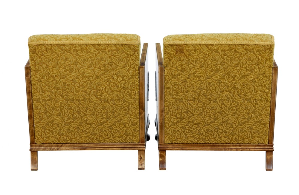 A pair of Art Deco lounge armchairs featuring light birch and elm veneered side panels, golden yellow patterned upholstery, and carved wooden feet. View X