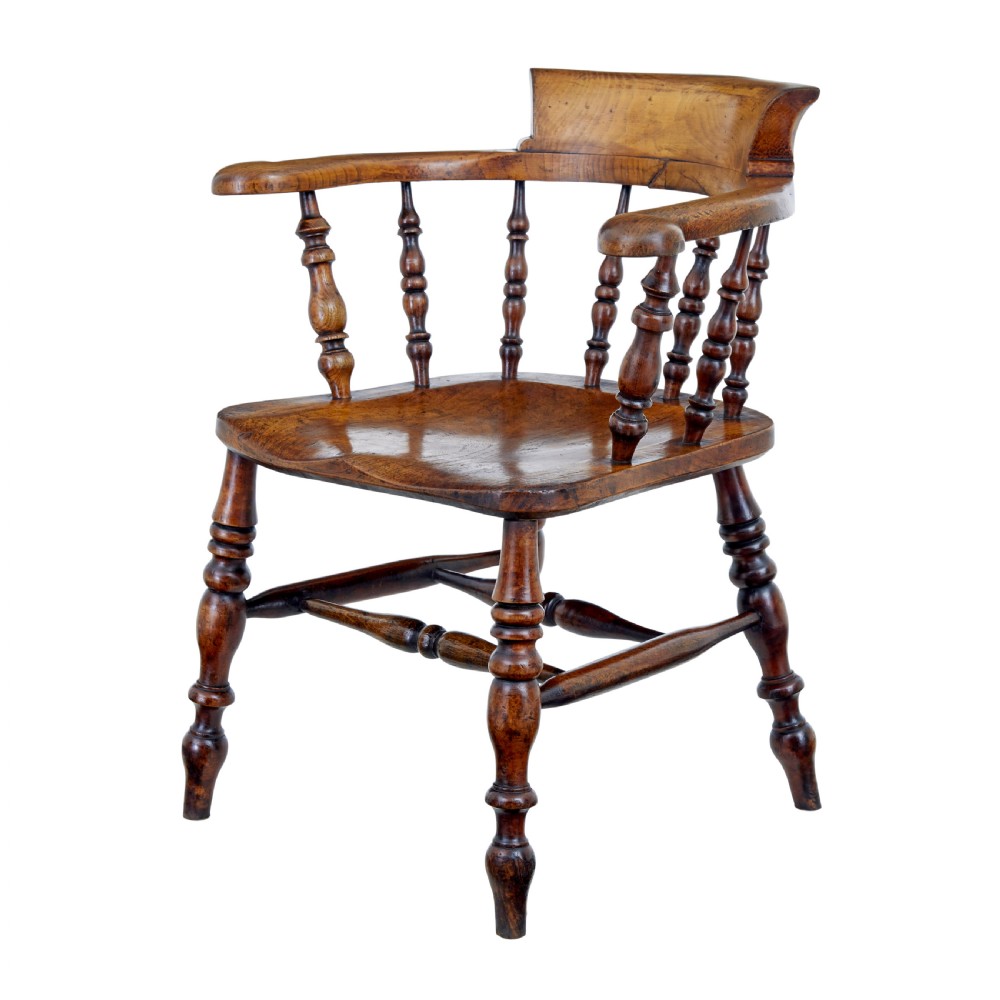 A mid-19th-century Victorian elm captains armchair with turned spindles, a contoured wooden seat, and turned legs.