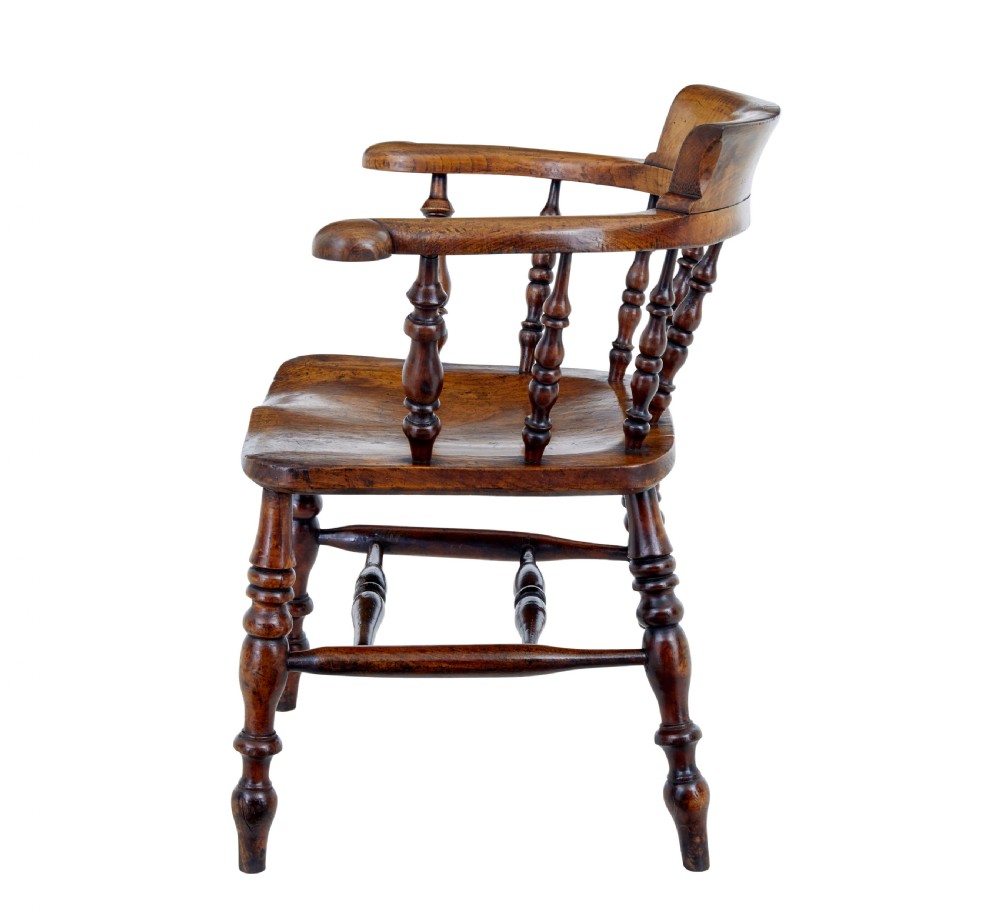 A mid-19th-century Victorian elm captains armchair with turned spindles, a contoured wooden seat, and turned legs. View III