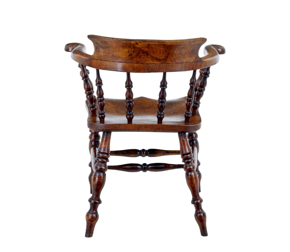 A mid-19th-century Victorian elm captains armchair with turned spindles, a contoured wooden seat, and turned legs. View V