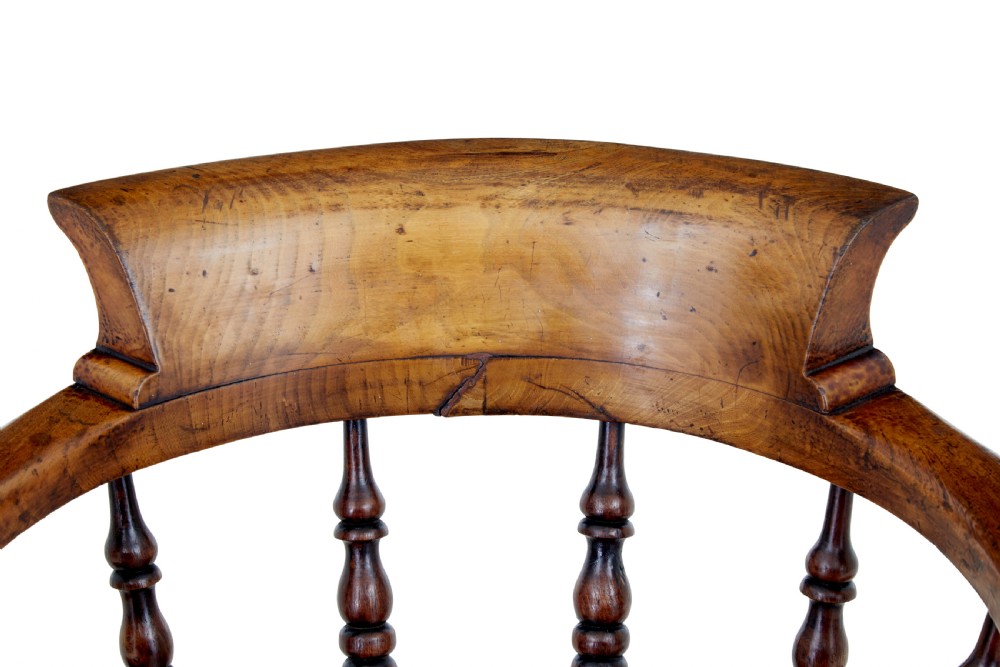 A mid-19th-century Victorian elm captains armchair with turned spindles, a contoured wooden seat, and turned legs. View VI