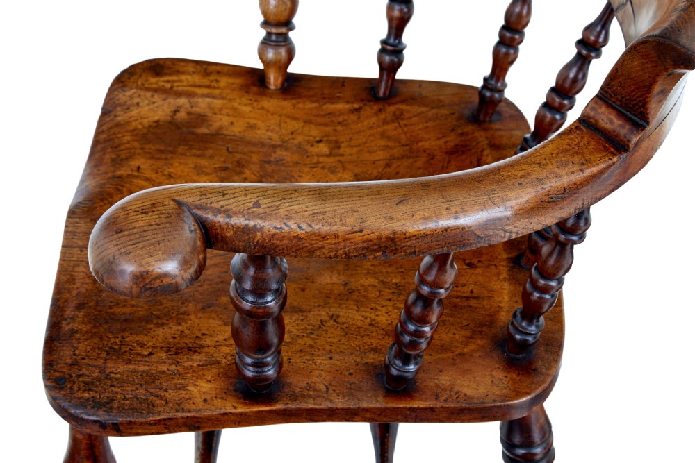 A mid-19th-century Victorian elm captains armchair with turned spindles, a contoured wooden seat, and turned legs. View IX