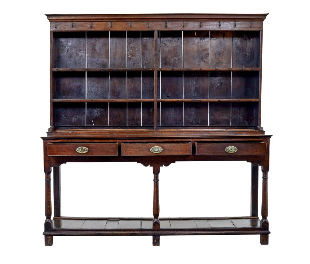 An early nineteenth-century Welsh oak dresser featuring a tall open plate rack with hooks above a three-drawer base supported by turned front legs and a lower pot board. View III