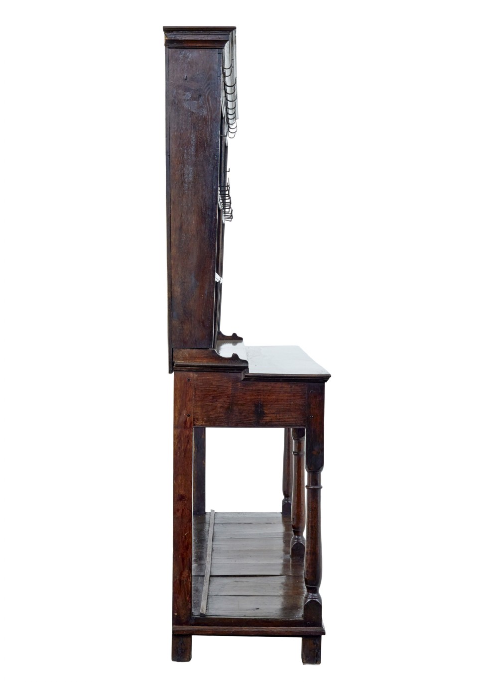 An early nineteenth-century Welsh oak dresser featuring a tall open plate rack with hooks above a three-drawer base supported by turned front legs and a lower pot board. View V