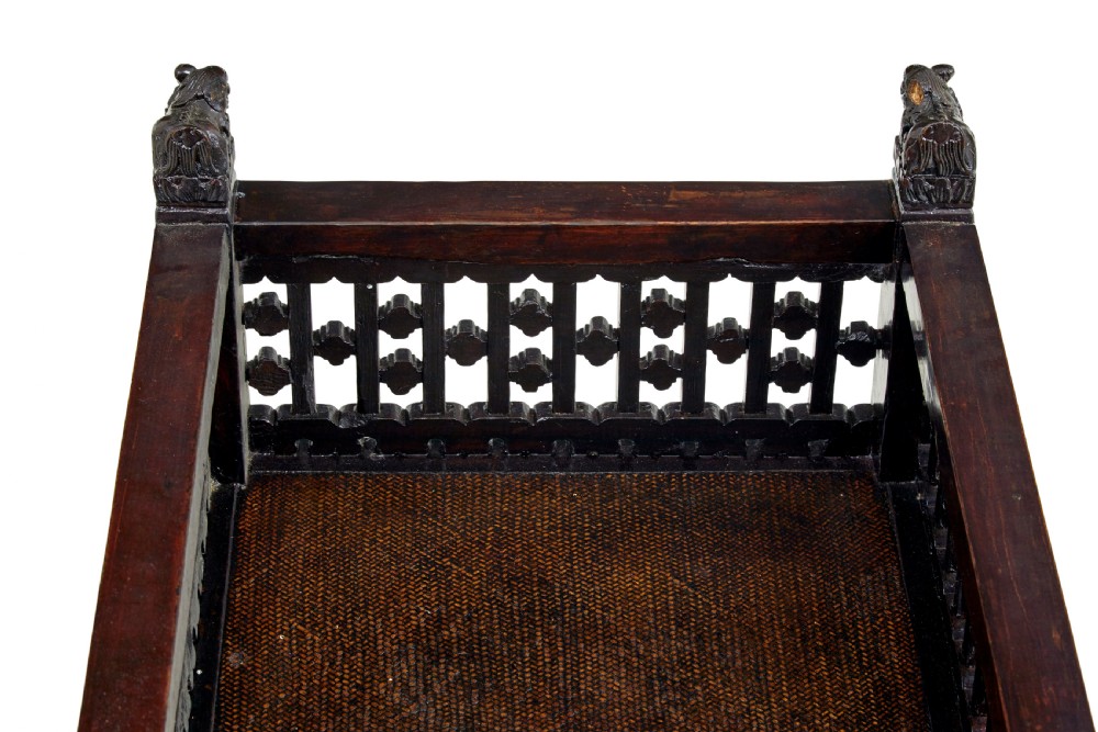 A 19th-century dark lacquered Chinese childs bed featuring carved lattice sides and guardian lion corner finials. View VII