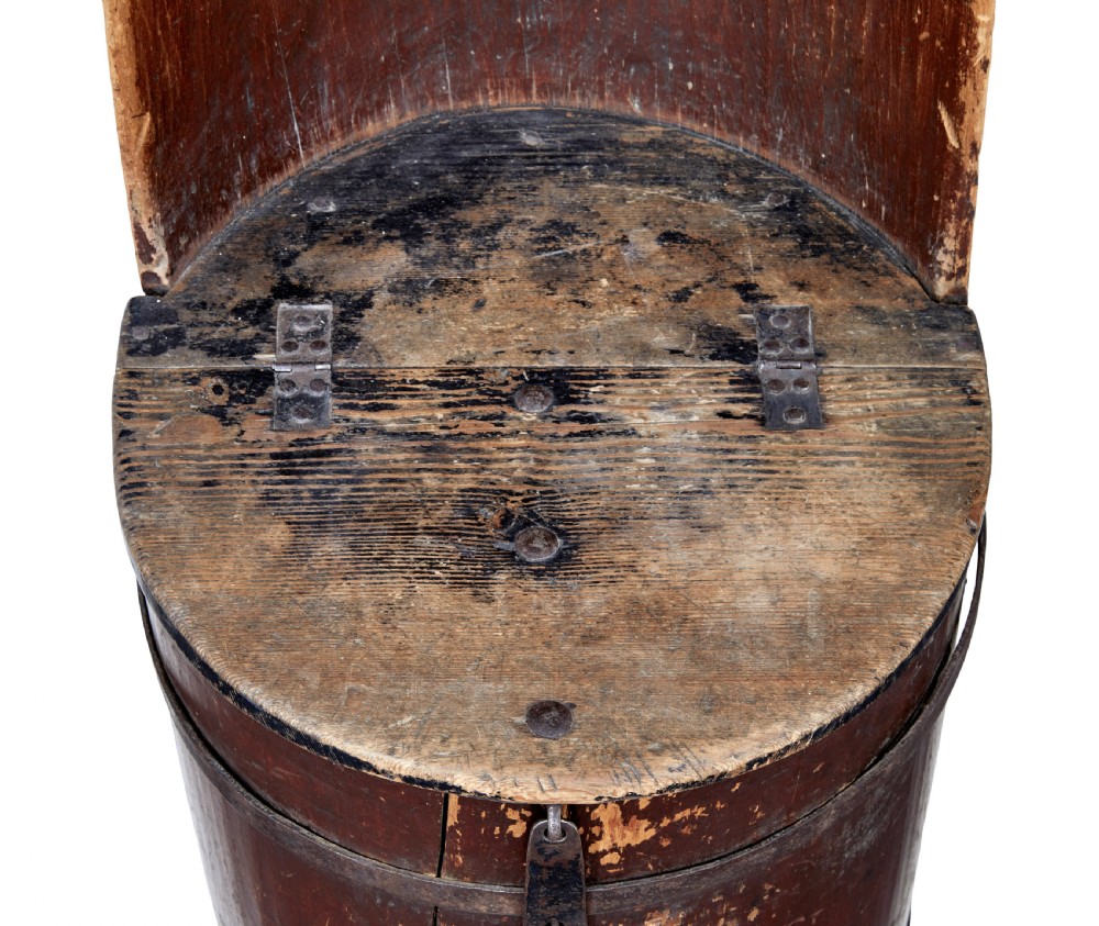 A 19th-century Swedish pine dugout chair featuring a dark patinated finish, rounded backrest, cylindrical body bound with iron straps, and a hinged timber seat. View VII