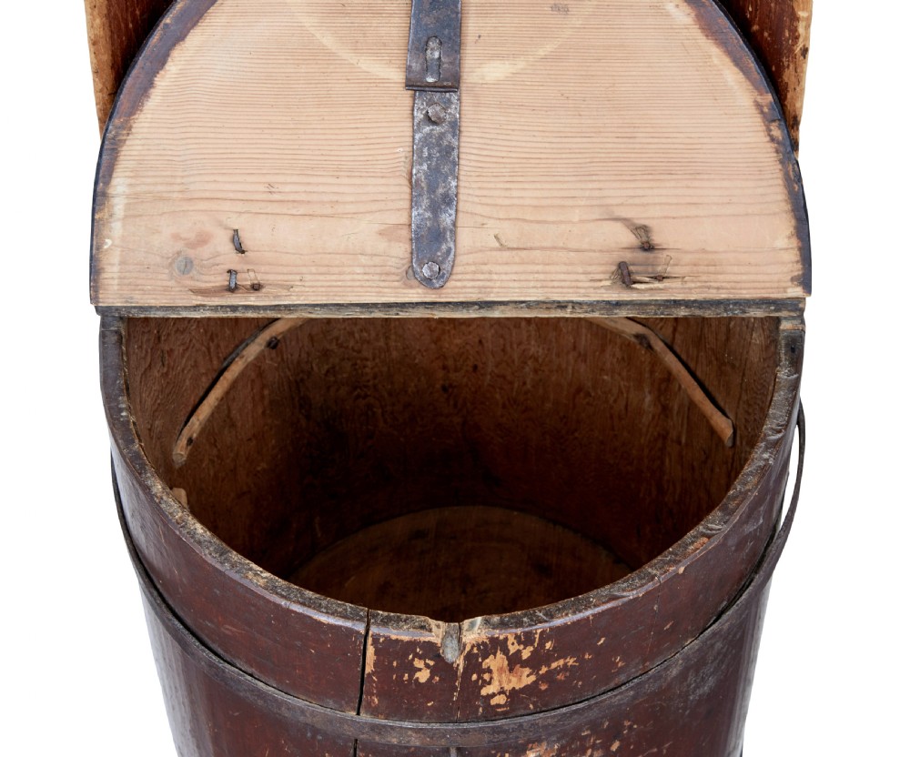 A 19th-century Swedish pine dugout chair featuring a dark patinated finish, rounded backrest, cylindrical body bound with iron straps, and a hinged timber seat. View VIII