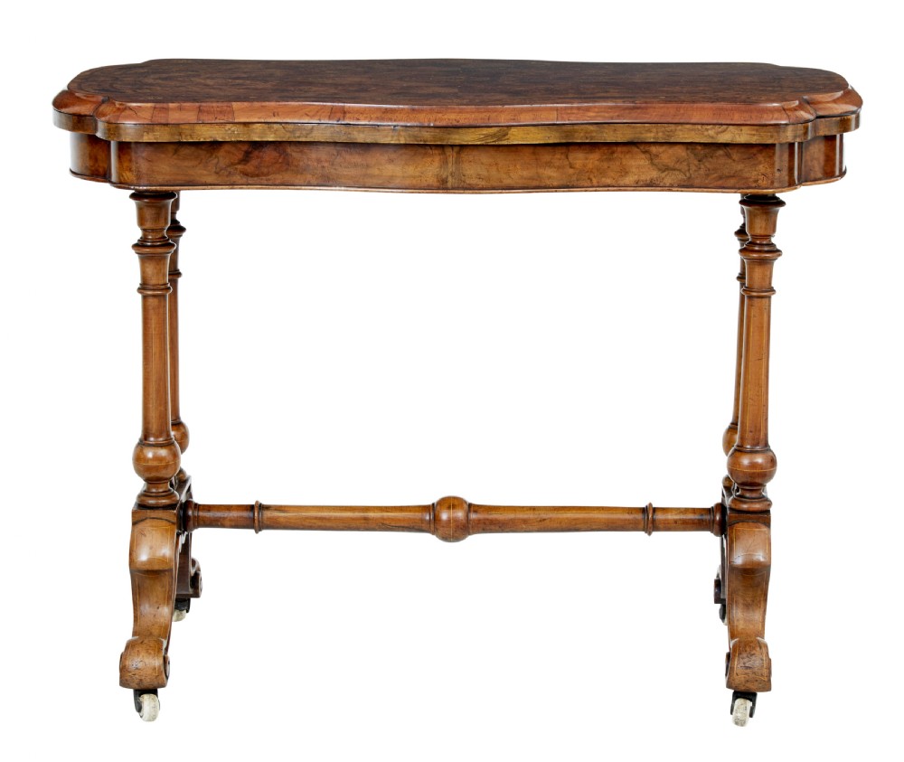 A 19th-century Victorian walnut fold-over card table featuring turned dual pedestal legs, a central stretcher rail, scroll feet, and ceramic castors. View II