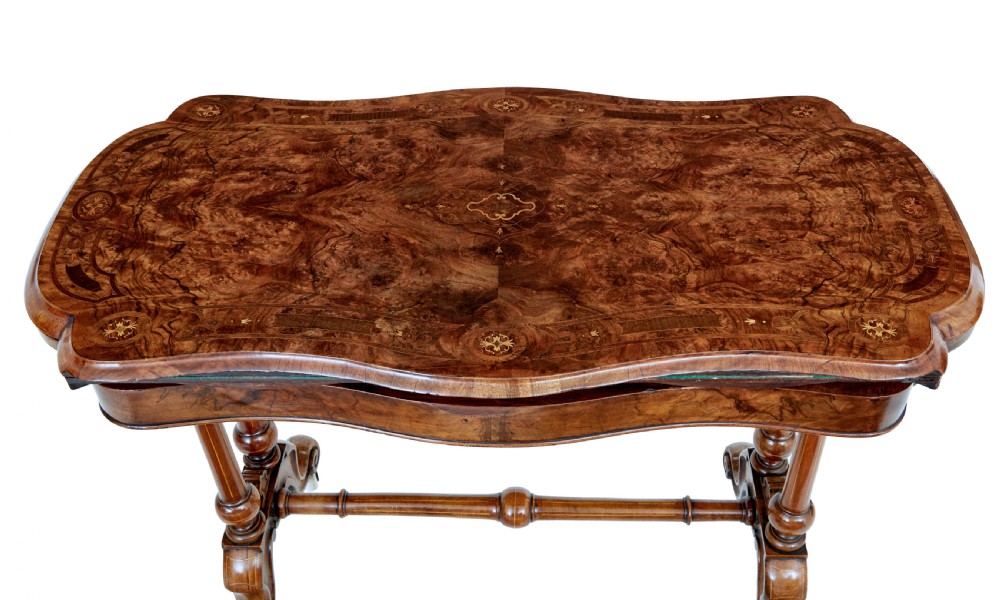 A 19th-century Victorian walnut fold-over card table featuring turned dual pedestal legs, a central stretcher rail, scroll feet, and ceramic castors. View IX