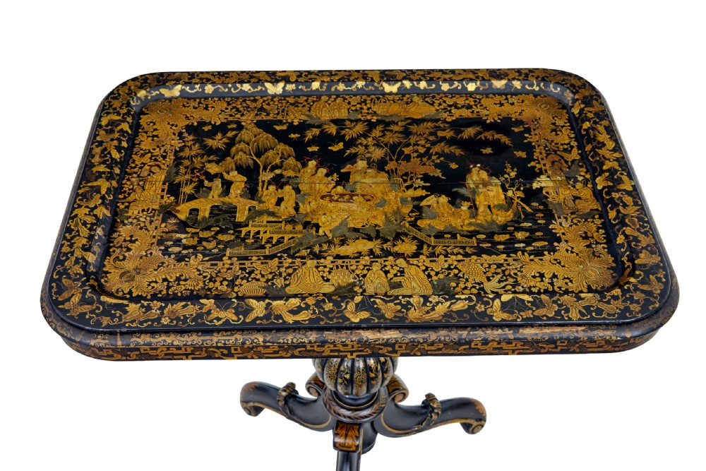 A 19th-century black lacquered pedestal table featuring hand-painted gold chinoiserie motifs, a tray top, turned central column, and tripod feet. View V