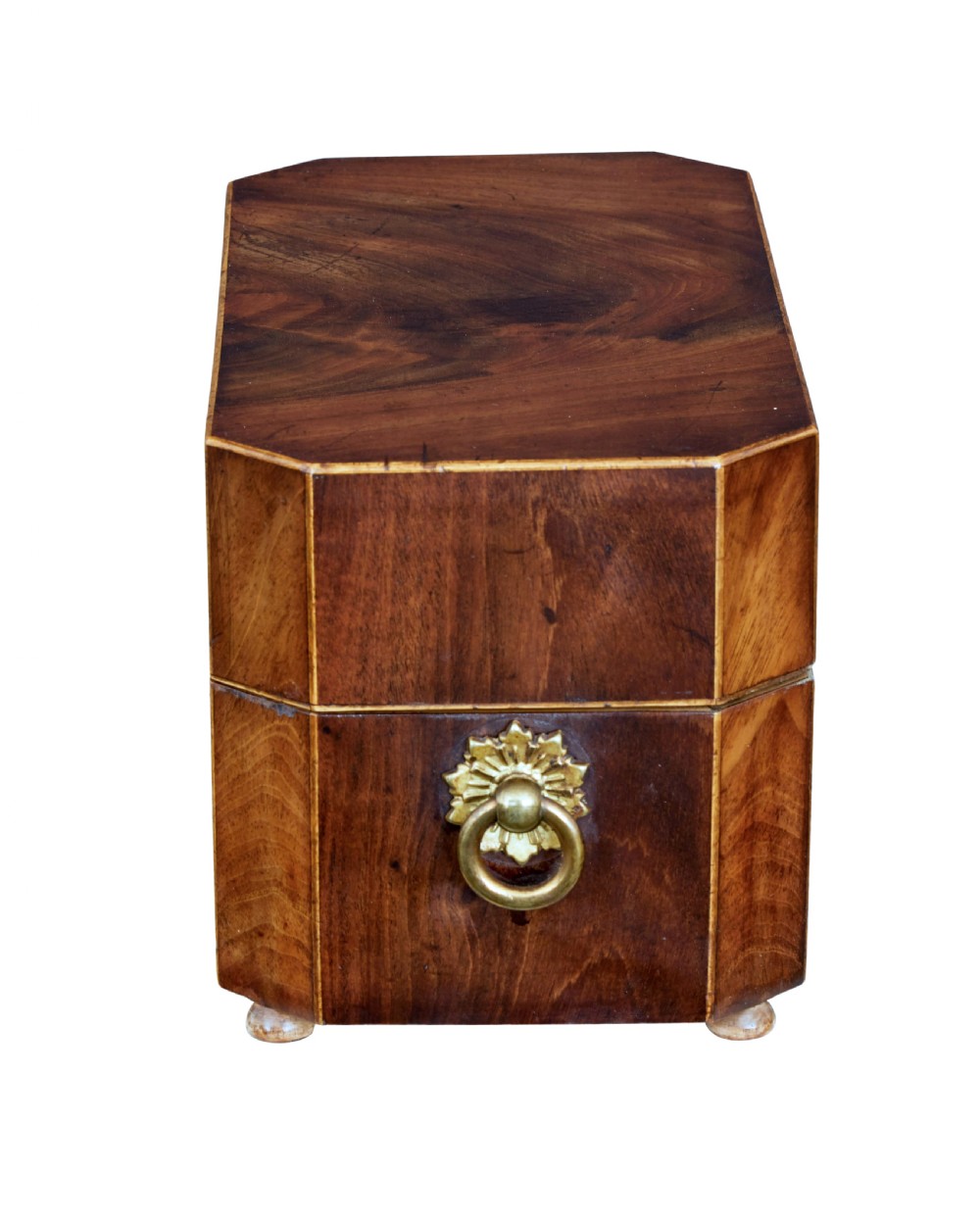 An early 19th-century mahogany tea caddy featuring a canted octagonal shape, brass side ring handles, a brass keyhole escutcheon, and bun feet. View IV