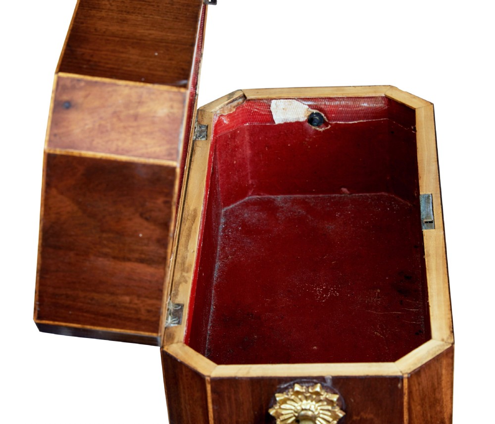 An early 19th-century mahogany tea caddy featuring a canted octagonal shape, brass side ring handles, a brass keyhole escutcheon, and bun feet. View VI