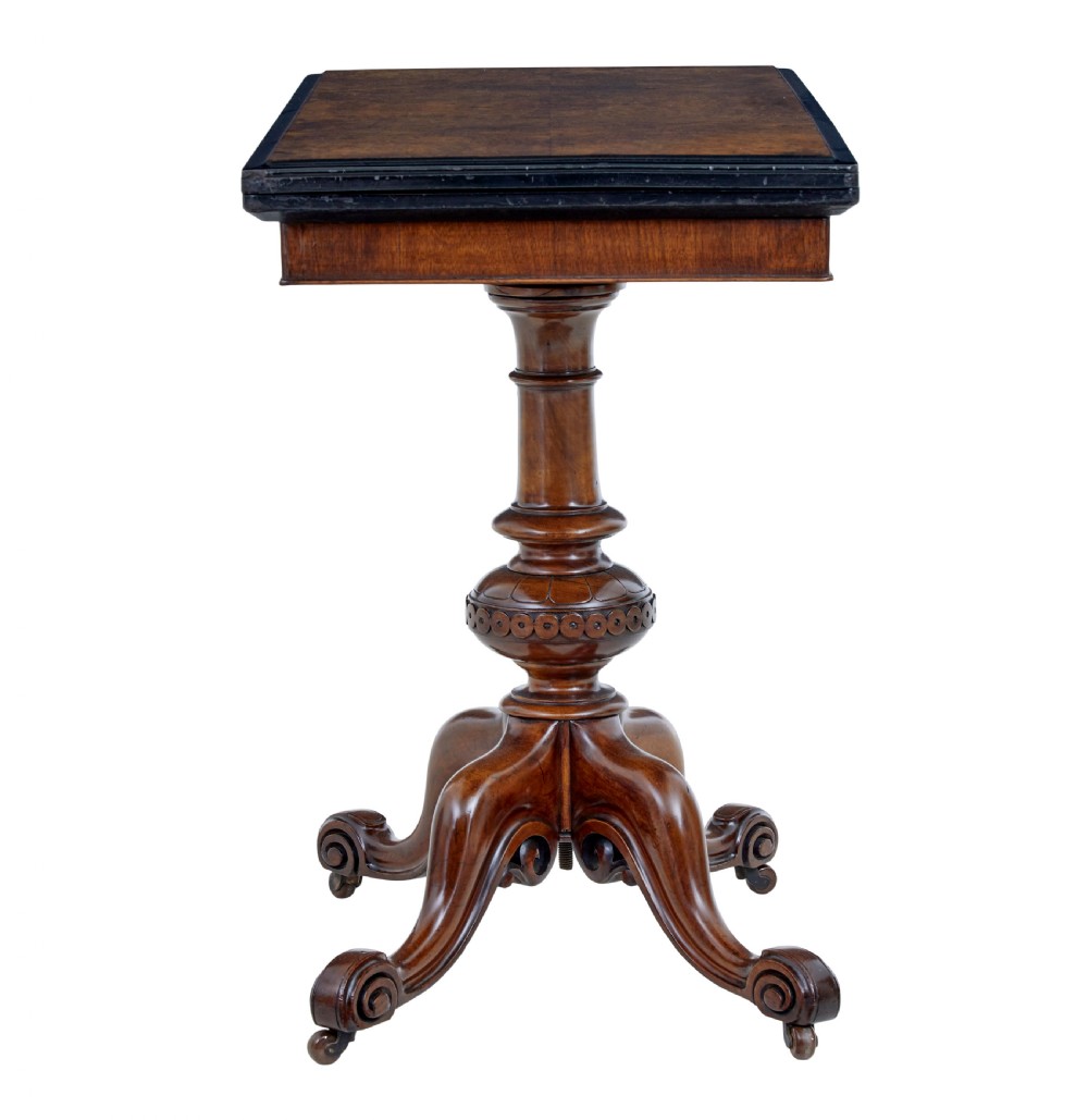 A 19th-century carved walnut fold-over card table featuring an ebonised top edge, a turned central stem, and four carved scroll feet with castors. View III