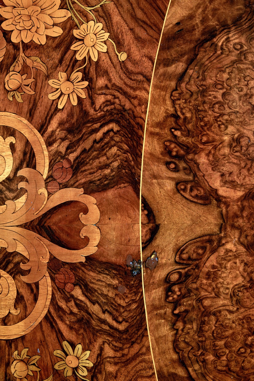A 19th-century oval walnut tilt-top table with intricate floral marquetry inlay and a carved pedestal base with brass castors. View VI