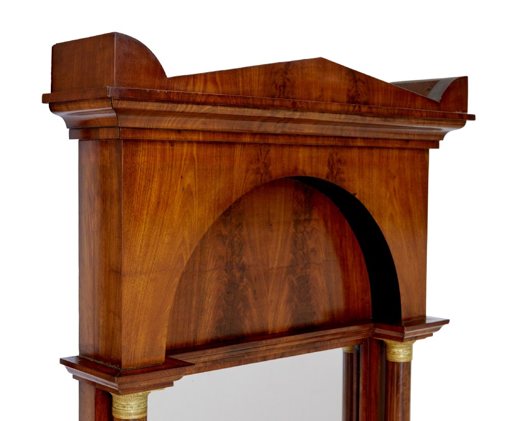 A tall nineteenth-century Empire Revival mahogany pier mirror featuring an architectural pediment, recessed arch with flame mahogany veneer, and flanking columns with gilded capitals. View IV