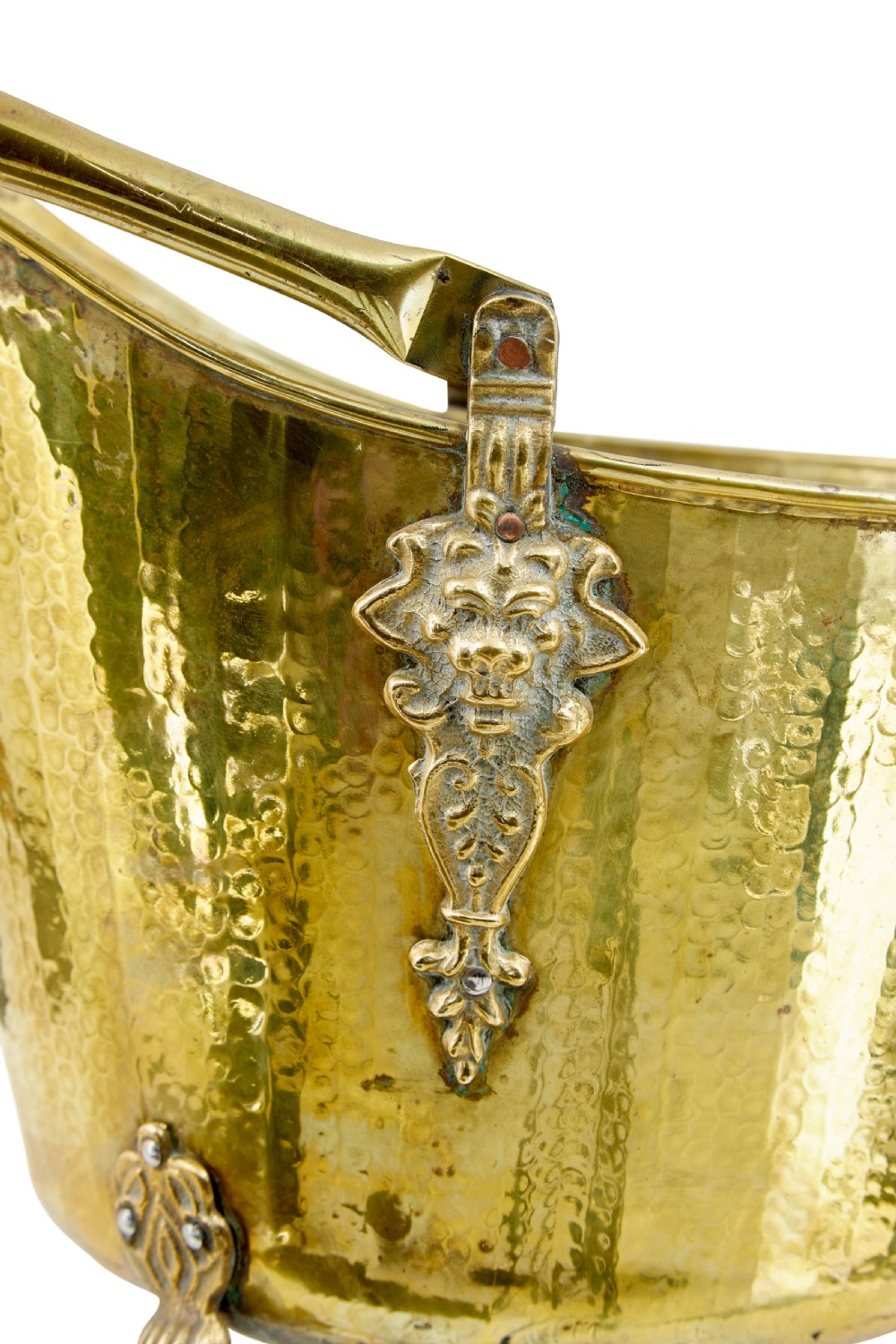 A 19th-century hammered brass helmet coal scuttle with an overhead handle, ornate side mounts, and paw feet. View VII