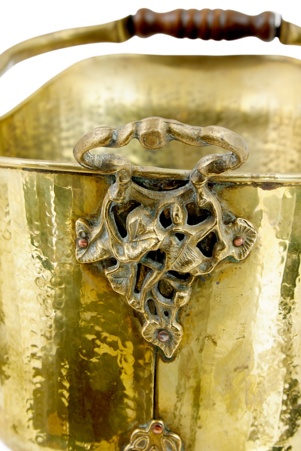 A 19th-century hammered brass helmet coal scuttle with an overhead handle, ornate side mounts, and paw feet. View VIII