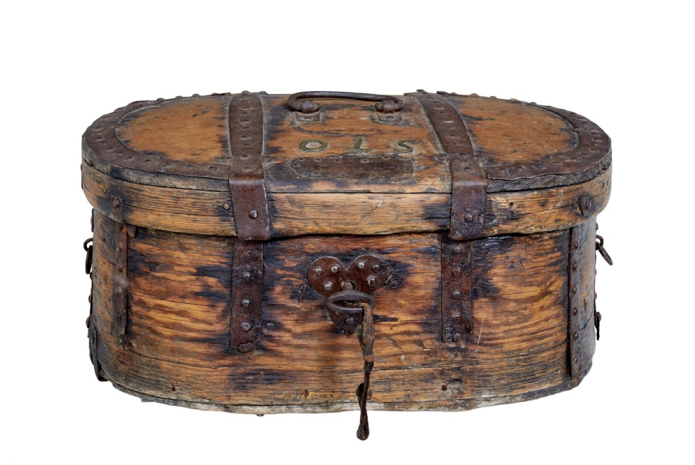 An early 18th-century Scandinavian oval oak box featuring wrought iron binding straps, studded rivets, and carved initials on the top. View V