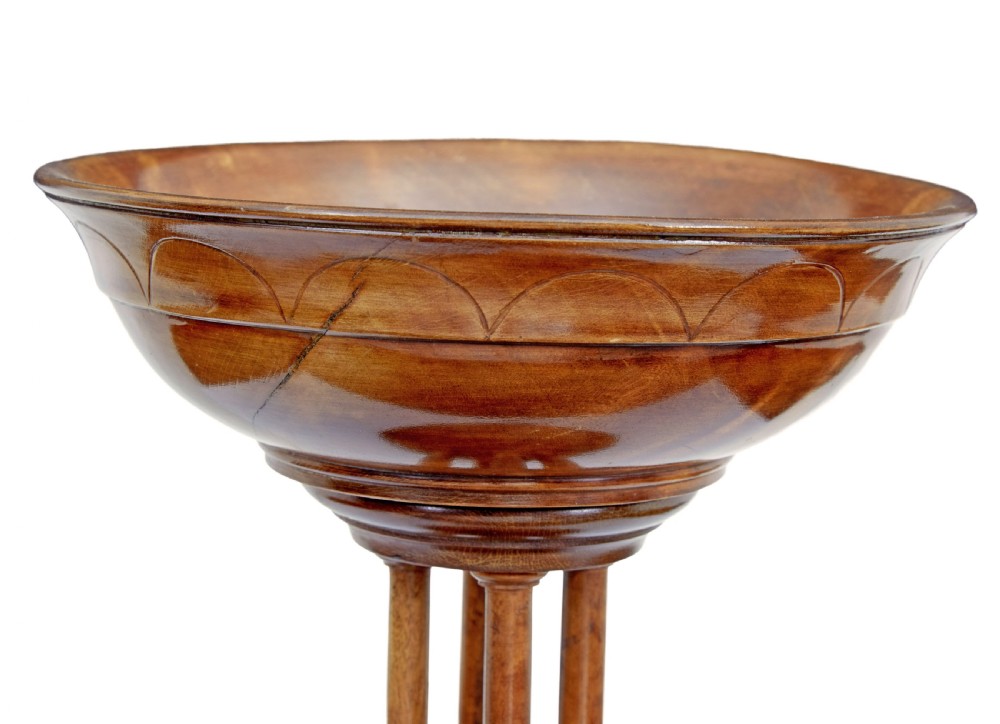 A 19th-century carved walnut tazza featuring a shallow turned bowl resting on slender columnar supports and a stepped circular base. View V