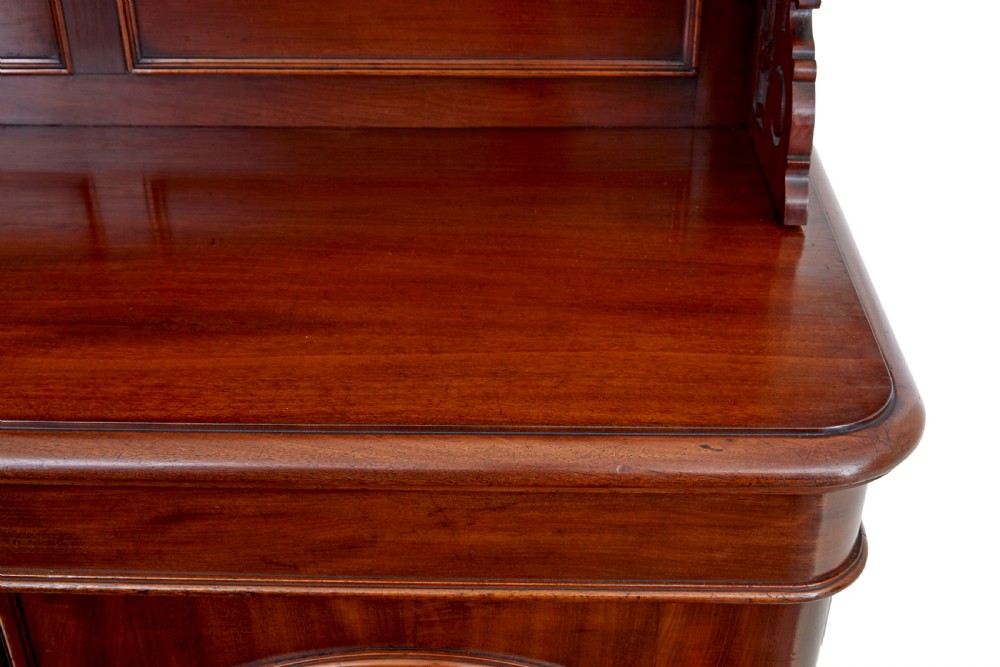 A 19th-century French mahogany chiffonier sideboard featuring a carved pediment upper tier with inset mirror panels over a two-door base cabinet. View VIII