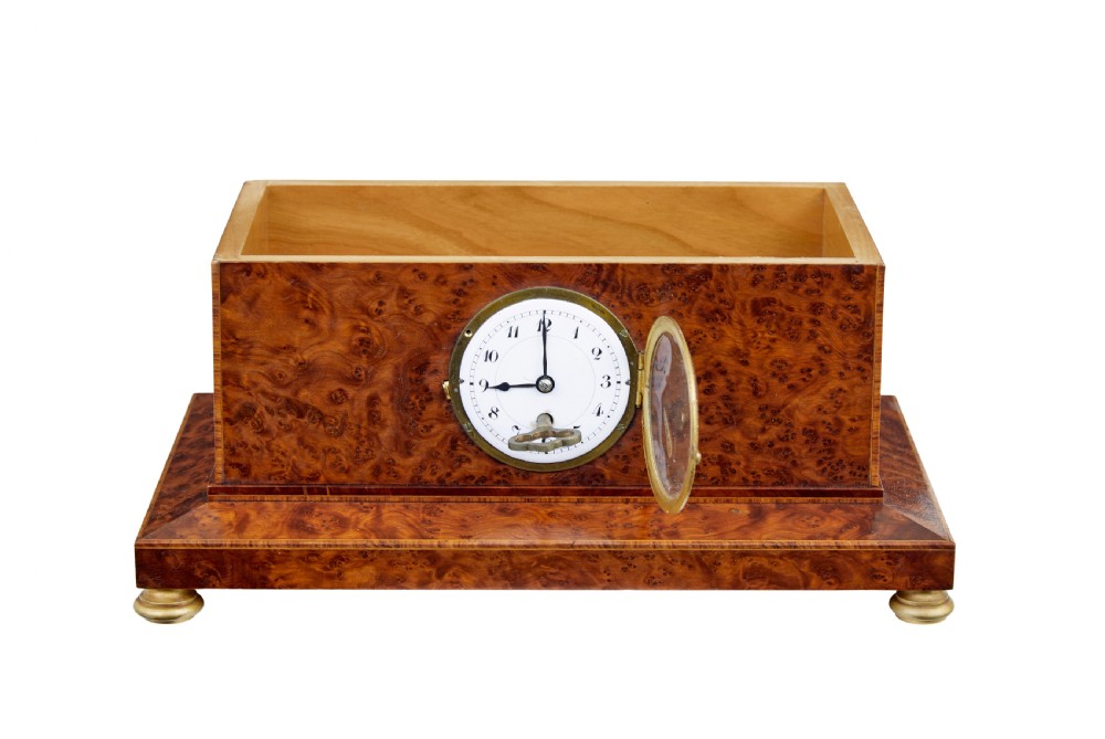 An early 20th-century burr yew desktop box featuring a circular clock face on the front, gilt brass top ornamentation, and brass feet. View II