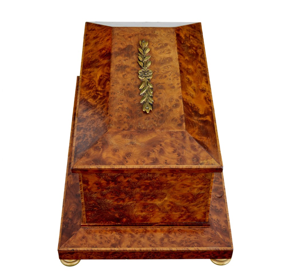 An early 20th-century burr yew desktop box featuring a circular clock face on the front, gilt brass top ornamentation, and brass feet. View VI