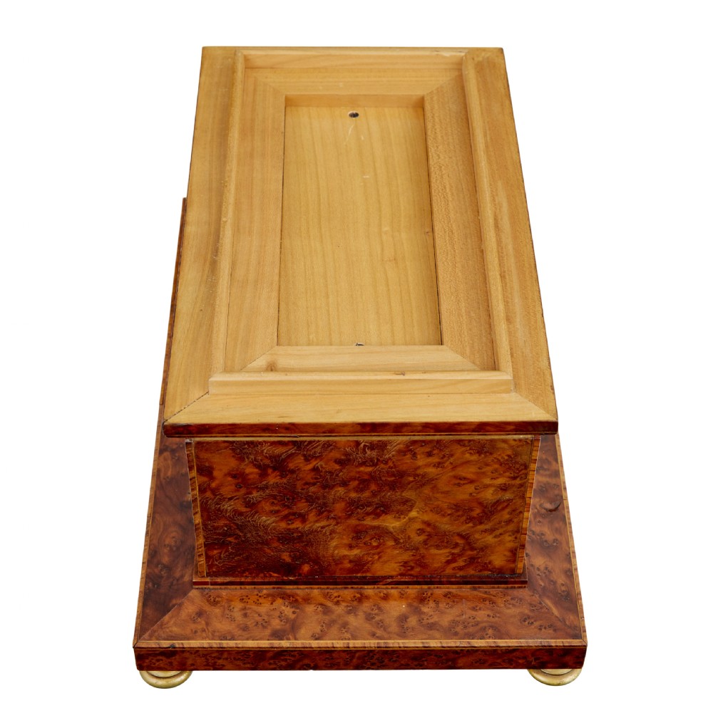 An early 20th-century burr yew desktop box featuring a circular clock face on the front, gilt brass top ornamentation, and brass feet. View VII