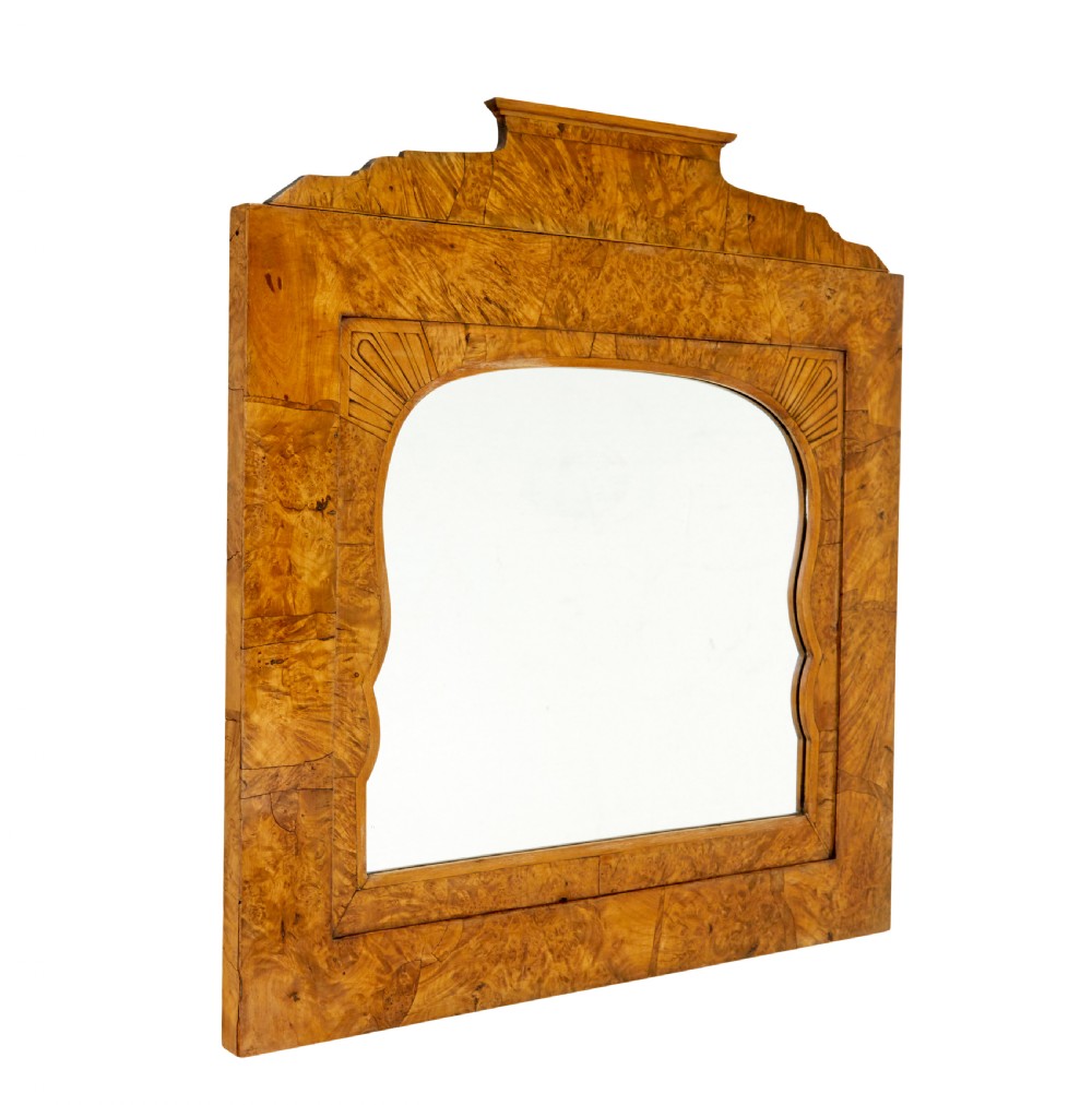 A nineteenth-century Biedermeier mantle mirror featuring a figured root birch veneer frame with a stepped crest and carved fan spandrel details. View IV