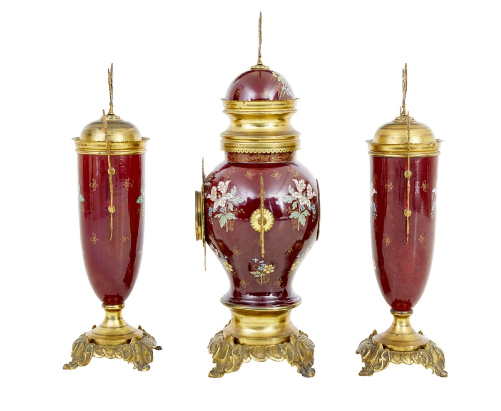 A nineteenth-century three-piece French toleware garniture set comprising a central clock urn and two matching side urns in crimson with hand-painted flowers and gilt mounts. View II