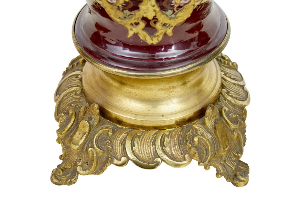 A nineteenth-century three-piece French toleware garniture set comprising a central clock urn and two matching side urns in crimson with hand-painted flowers and gilt mounts. View VI