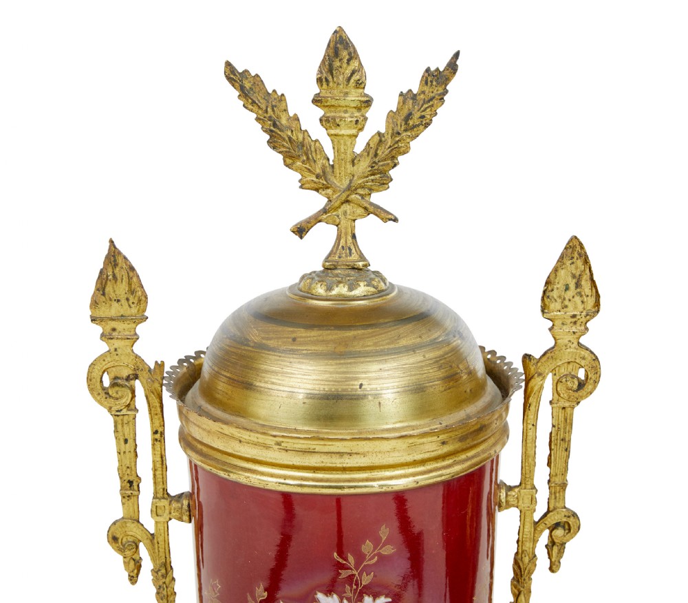 A nineteenth-century three-piece French toleware garniture set comprising a central clock urn and two matching side urns in crimson with hand-painted flowers and gilt mounts. View VIII