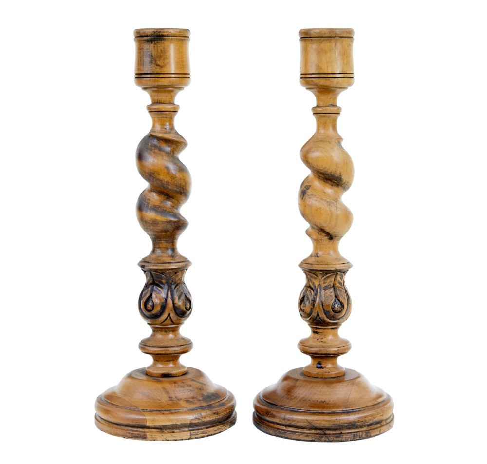 A pair of early 20th-century turned wood candlesticks featuring spiral stems, carved leaf accents, and wide circular bases. View II
