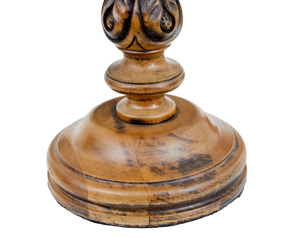 A pair of early 20th-century turned wood candlesticks featuring spiral stems, carved leaf accents, and wide circular bases. View V