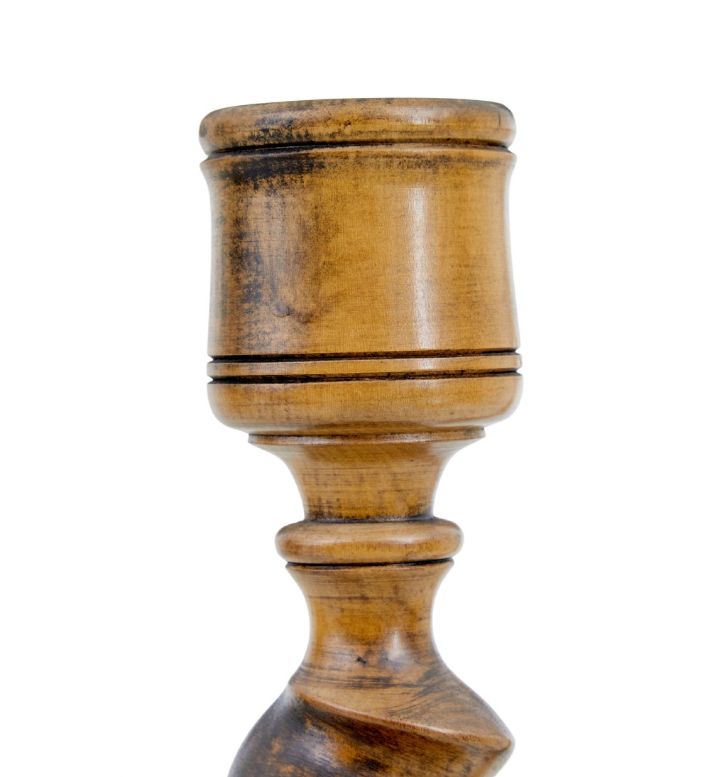 A pair of early 20th-century turned wood candlesticks featuring spiral stems, carved leaf accents, and wide circular bases. View VI