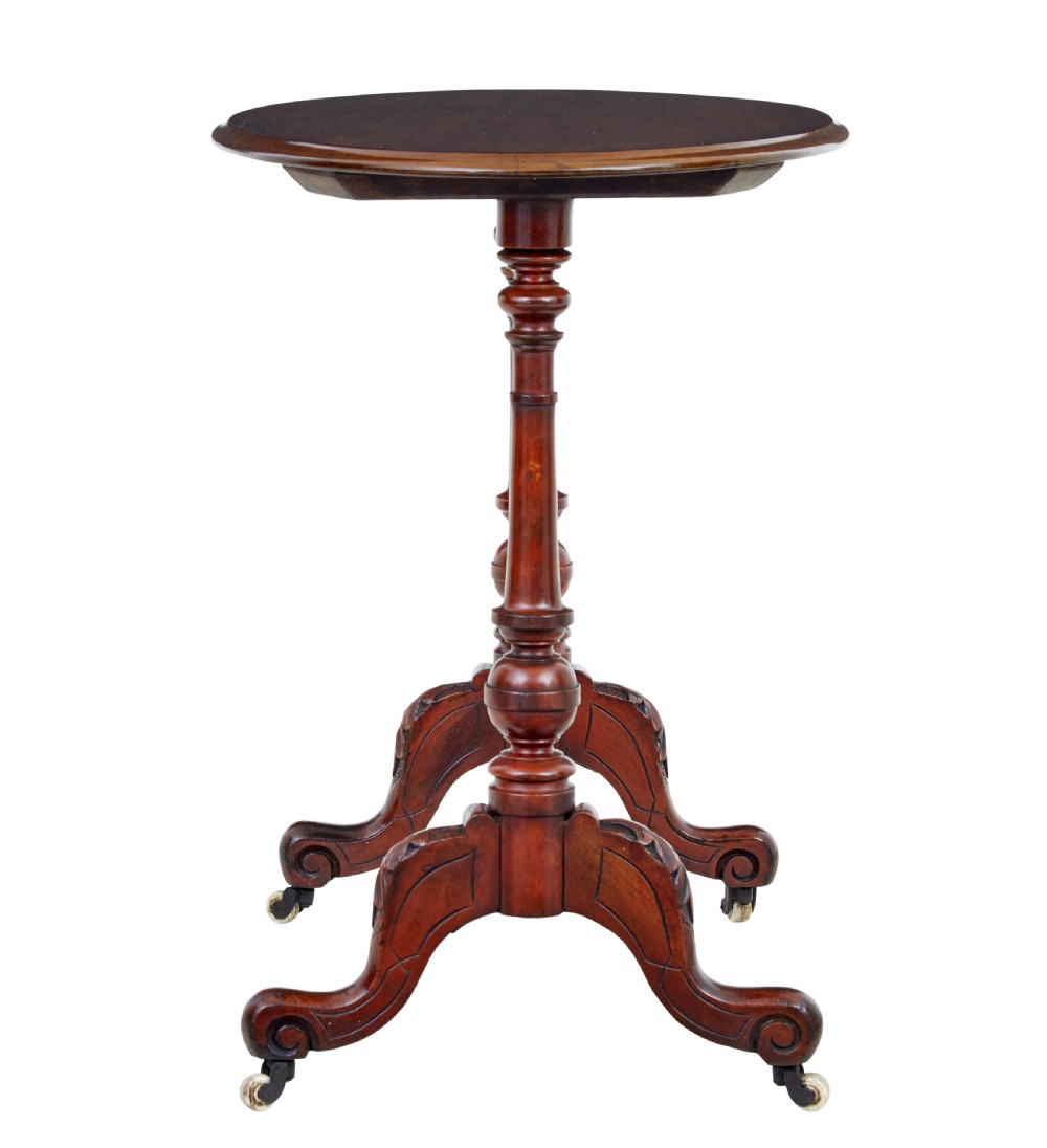 A 19th-century Victorian oval occasional table in polished walnut featuring twin turned support columns, carved legs, a central stretcher, and ceramic castors. View III