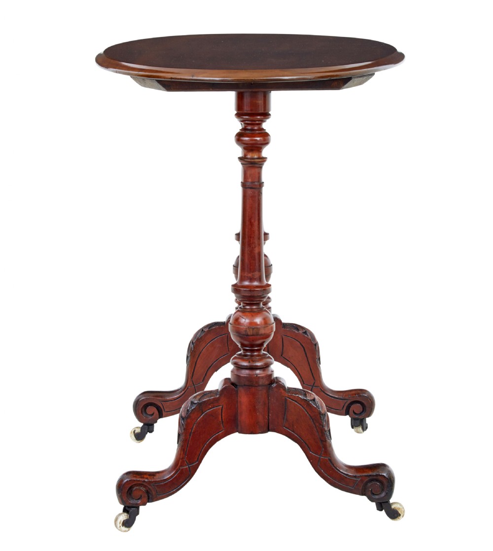 A 19th-century Victorian oval occasional table in polished walnut featuring twin turned support columns, carved legs, a central stretcher, and ceramic castors. View IV