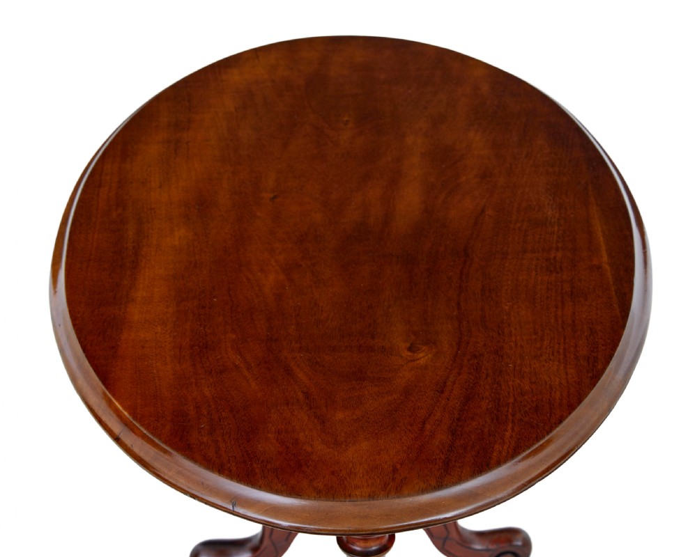 A 19th-century Victorian oval occasional table in polished walnut featuring twin turned support columns, carved legs, a central stretcher, and ceramic castors. View V