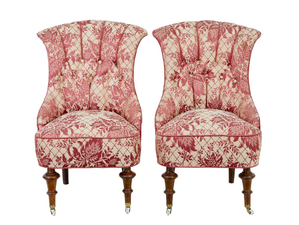 An early 20th century three-piece upholstered salon suite featuring a two-seater settee and two matching armchairs with pink and cream floral damask pattern, button-tufted fluted backs, and turned wooden legs with brass castors. View XII